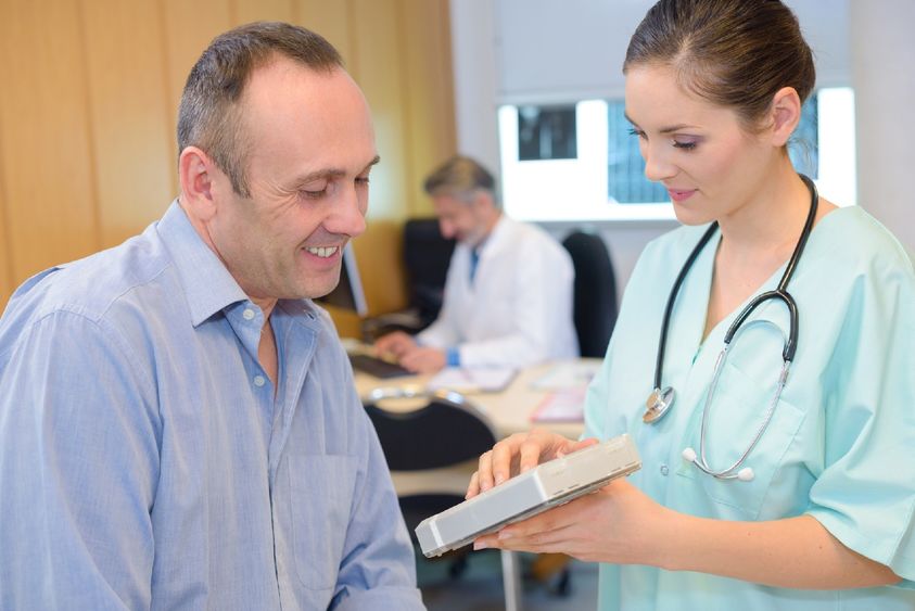 A medical assistant gets information from a patient.