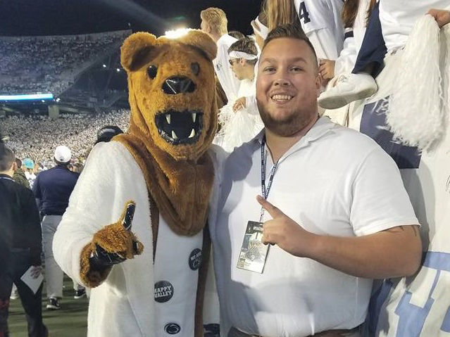 Penn State Behrend alumnus Colten Brown poses with the Nittany Lion at a White-Out game.