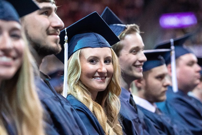 New graduates smile during a Penn State Behrend commencement program.