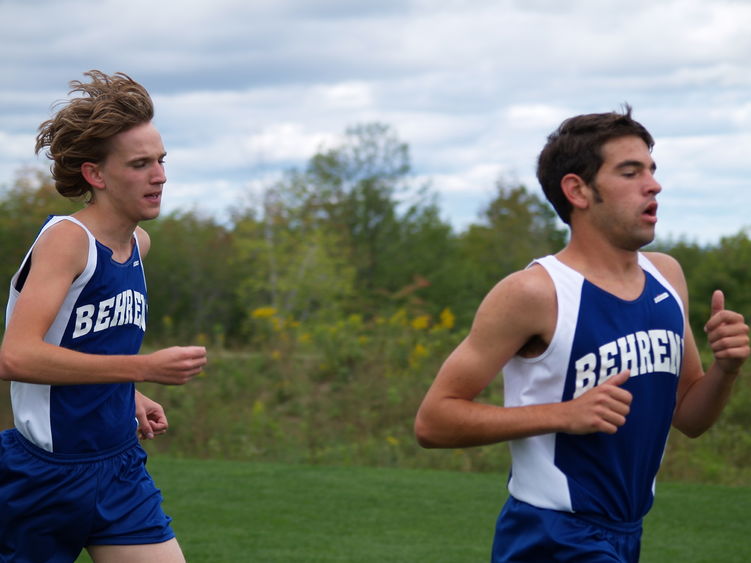 Two Penn State Behrend runners compete in a cross country race.