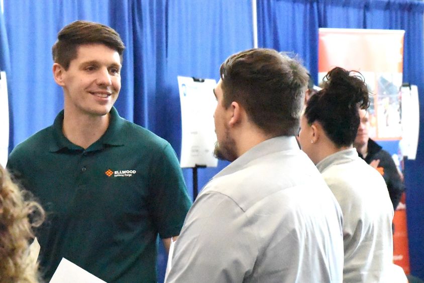 A recruiter for Ellwood National Forge talks with students at Penn State Behrend's career fair.