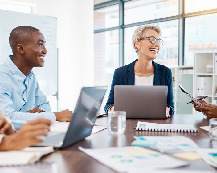 A group of people sit at table in an office space.