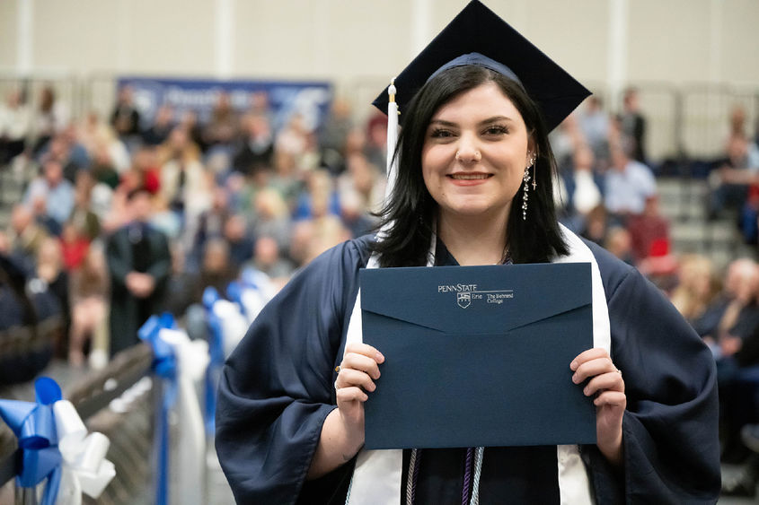Penn State Behrend graduate Gabi Watson holds her diploma.