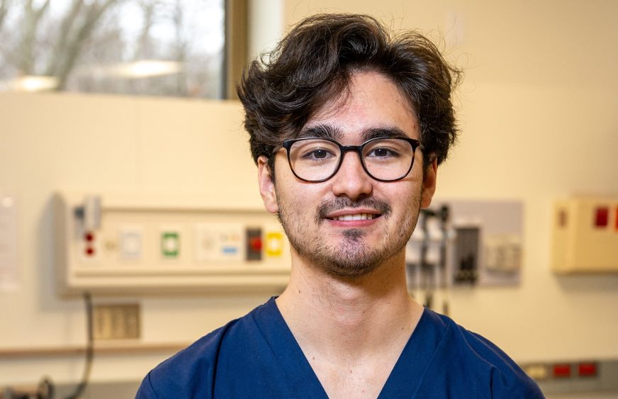 A portrait of Penn State Behrend graduate Grant Oishi in the college's nursing simulation lab.