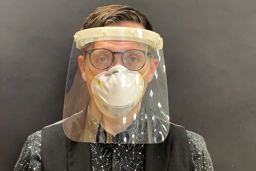 A man models a plastic medical face shield