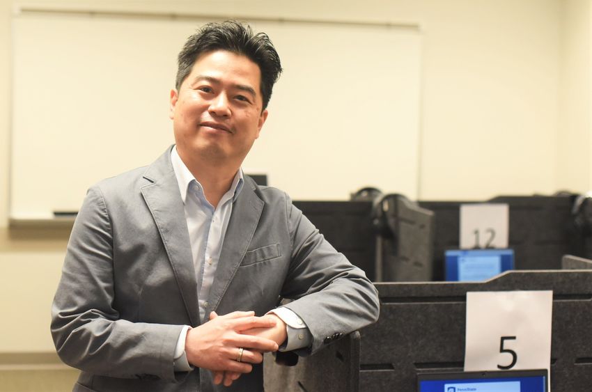 A Penn State Behrend faculty member poses near a computer workstation in the college's Raimy Behavioral Lab.