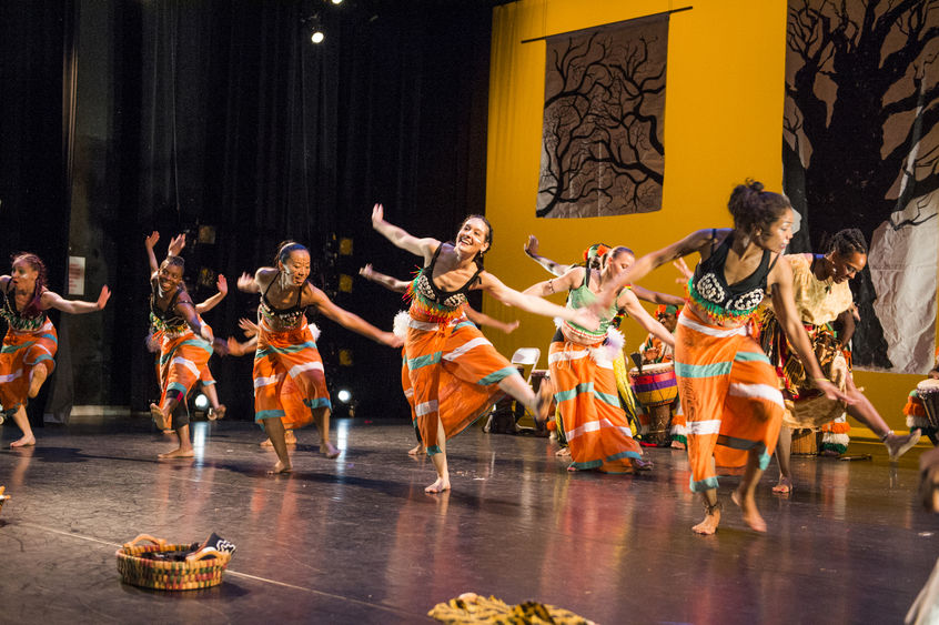 Members of the Kotchegna Dance Company dance on a stage.