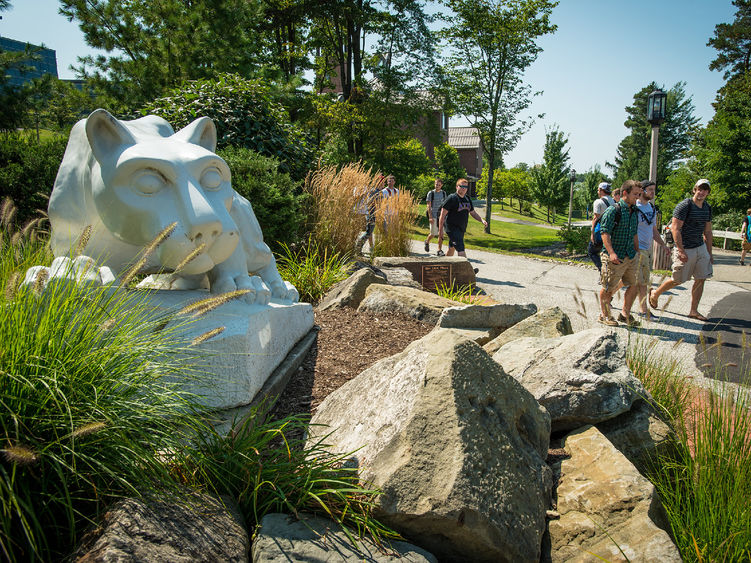 Students walk past the Nittany Lion shrine at Penn State Behrend.