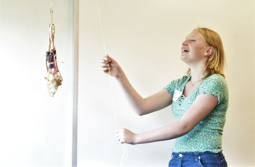 A female student drops a Barbie doll on a bungee cord at Penn State Behrend's Math Options Career Day.