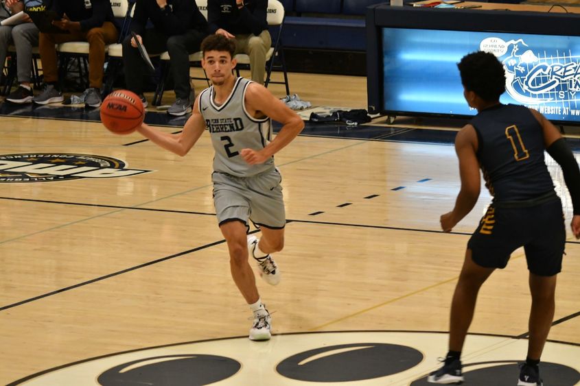 A Penn State Behrend basketball player passes the ball.