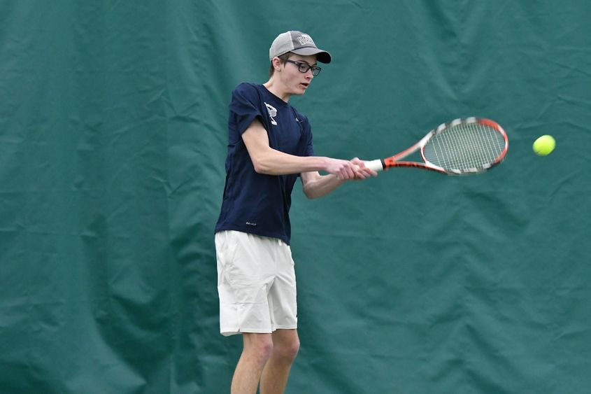 A Penn State Behrend tennis player hits a backhand stroke.