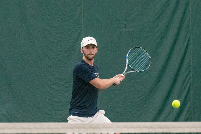 A member of the Penn State Behrend men's tennis team hits a backhand.