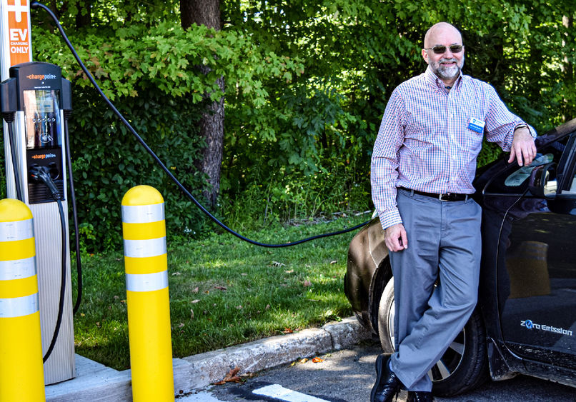 Penn State Behrend faculty member Michael Rutter charges an electric vehicle at a charging station on campus.