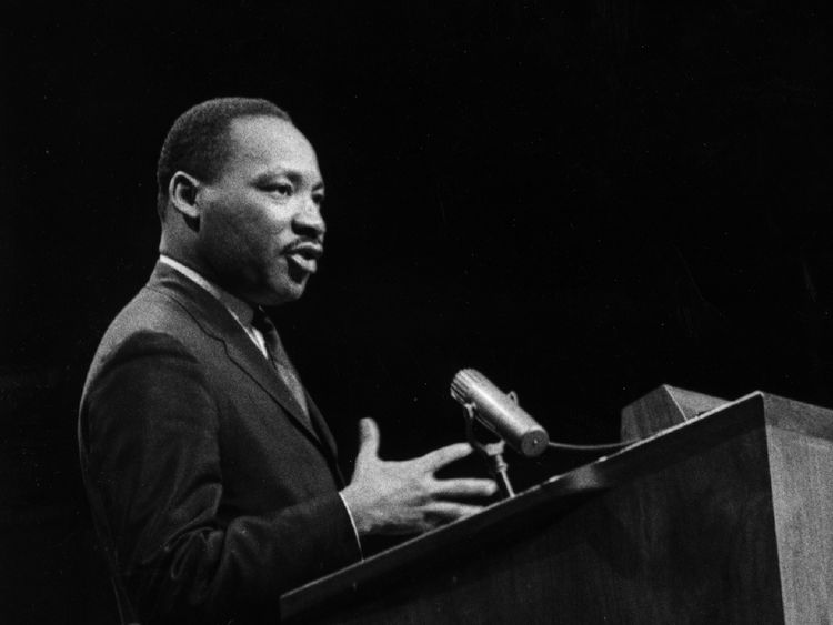 A black and white image of Martin Luther King speaking at a podium