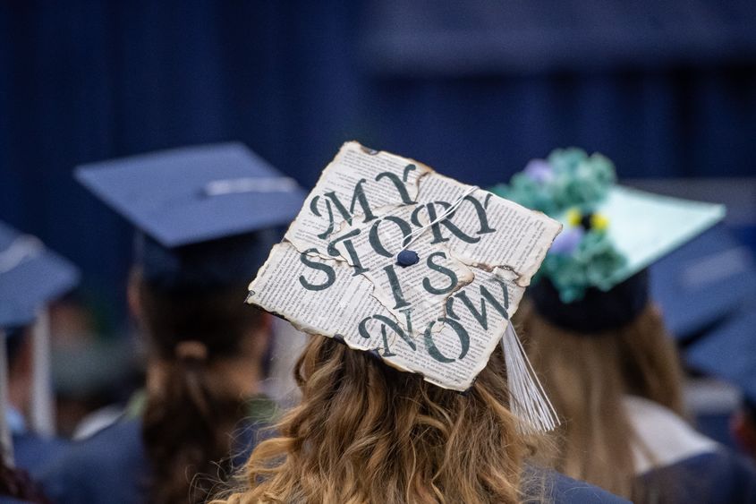 A close-up of a decorated mortarboard cap during a Penn State Behrend commencement program.