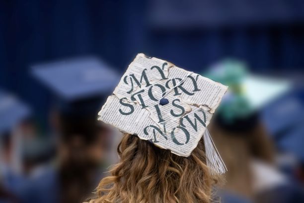 A close-up of a decorated mortarboard cap during a Penn State Behrend commencement program.