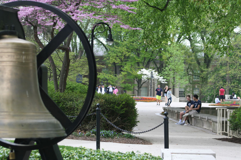 Students mingle around Old Main on the University Park campus