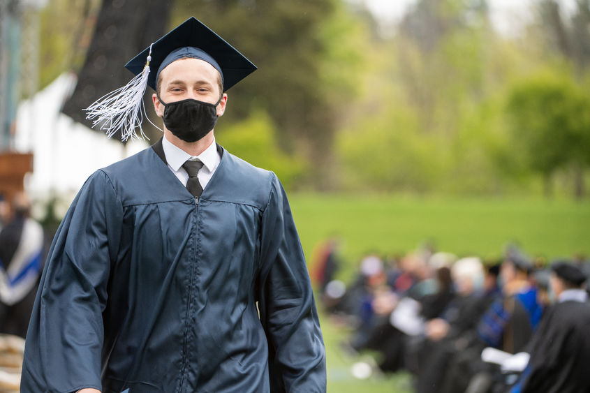 A Penn State Behrend graduate exits the commencement stage after receiving his diploma.