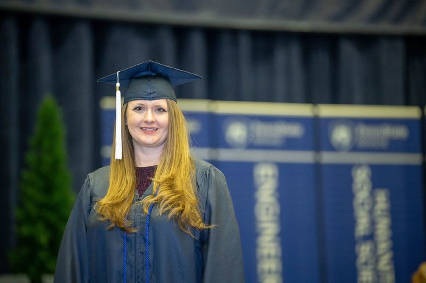 Brittany Anderson, a Penn State World Campus graduate who earned degrees in accounting and finance, poses before Penn State Behrend's December commencement program.