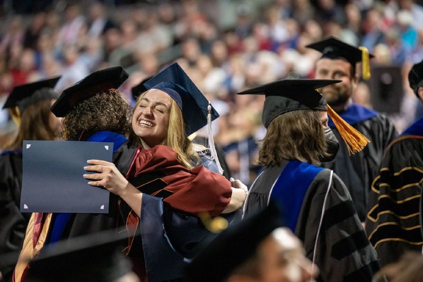 A student hugs a faculty member at Penn State Behrend's spring 2022 commencement program.