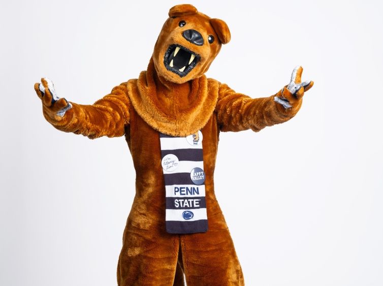 The Nittany Lion mascot extends both arms while facing the camera