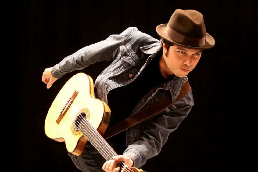 Rick Reyes of Cosmic Jibaros The musician Rick Reyes plays a guitar.