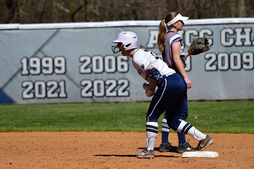 A Penn State Behrend softball player cheers while standing on base.