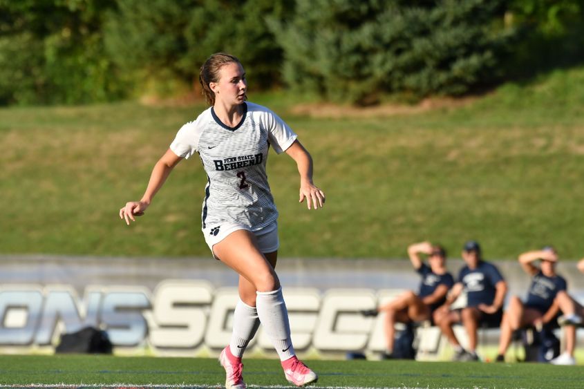 A Penn State Behrend female soccer player runs down the field toward the ball.