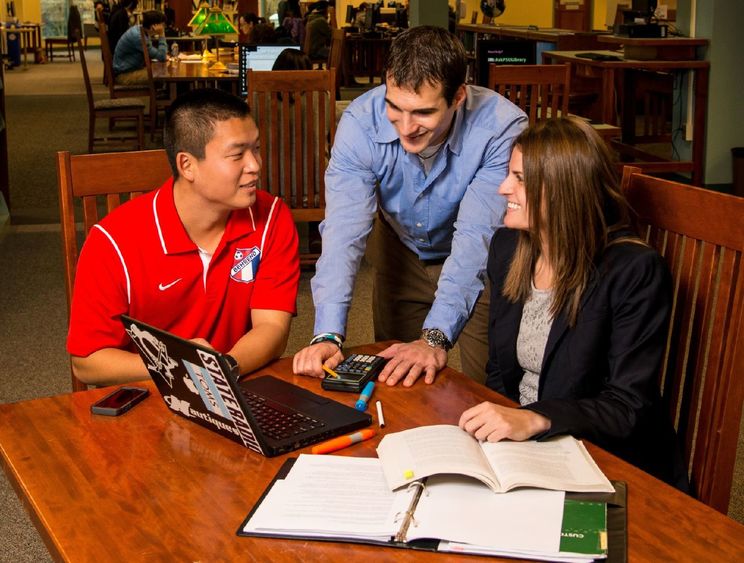 Three students in the MBA program collaborate in Lilley Library at Penn State Behrend.