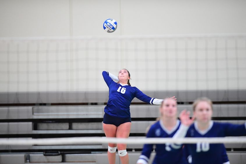 A Penn State Behrend volleyball player jumps while serving the ball.