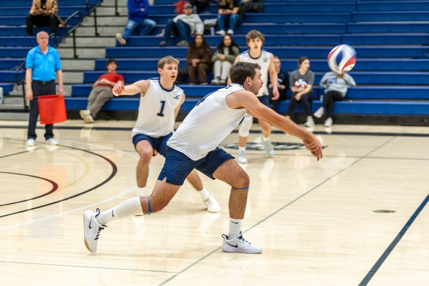 A Penn State Behrend volleyball player hits the ball with a dig.