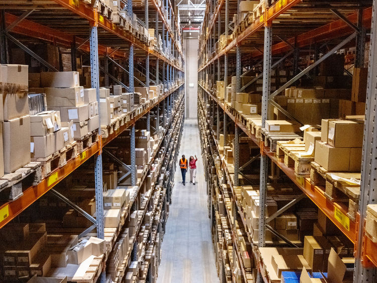 Two people walking through a warehouse