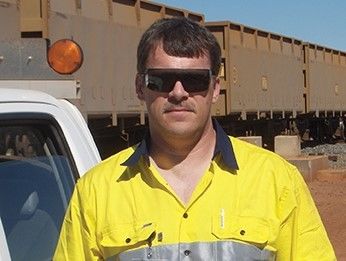 Warren Fargo, a Penn State Behrend graduate, stands in a railyard.