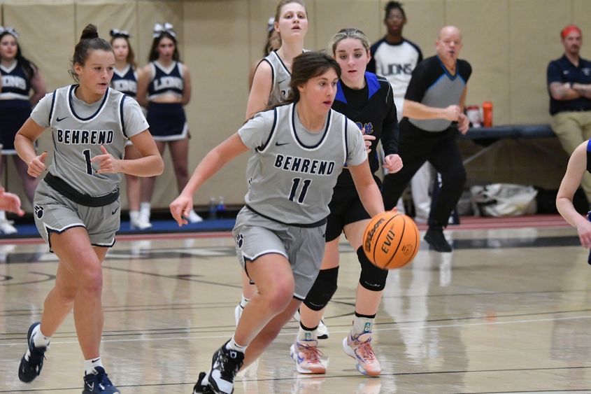 A Penn State Behrend female basketball player dribbles the ball upcourt.