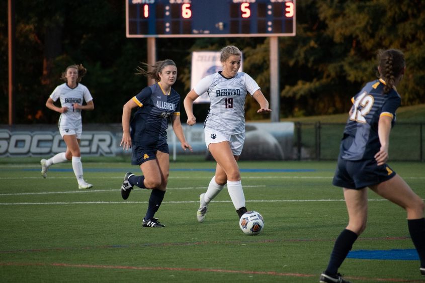 A Penn State Behrend women's soccer player kicks the ball downfield.