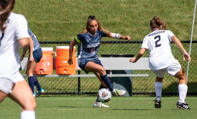 A Penn State Behrend soccer play dribbles the ball upfield.