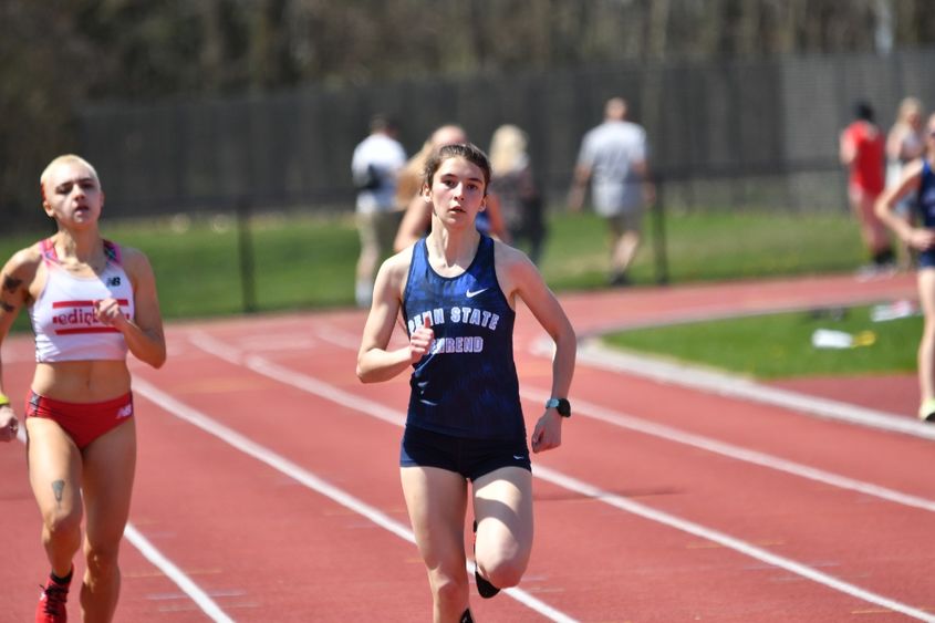 A Penn State Behrend runner competes in an outdoor track race.