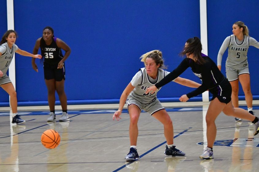 A Penn State Behrend basketball player scrambles for the ball.