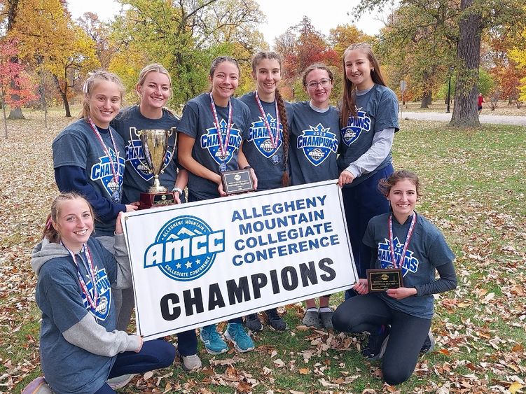 The Penn State Behrend women's cross country team poses with the AMCC championship banner