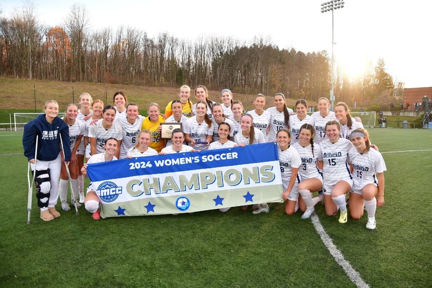 The Penn State Behrend women's soccer team poses with the AMCC championship banner.