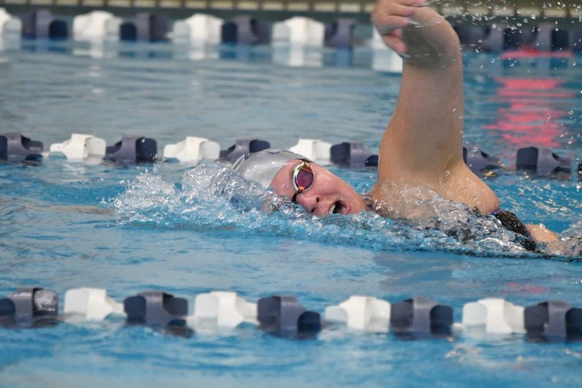 A female swimmer competes in a freestyle race