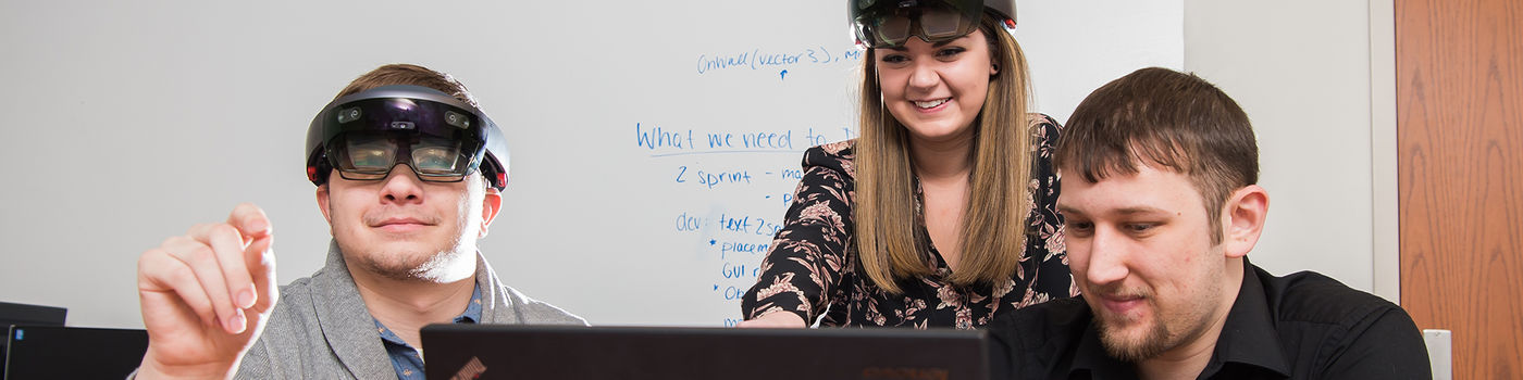 Students work with HoloLens mixed reality headsets and a computer at Penn State Behrend.
