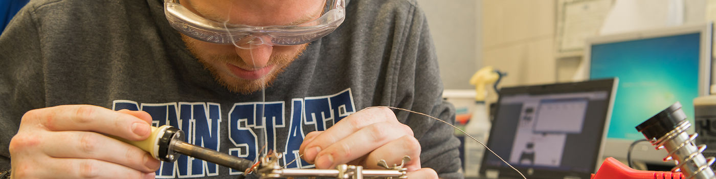 A Penn State Behrend student working on electrical components.