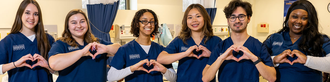 Penn State Behrend nursing students pose making heart shapes with their hands.