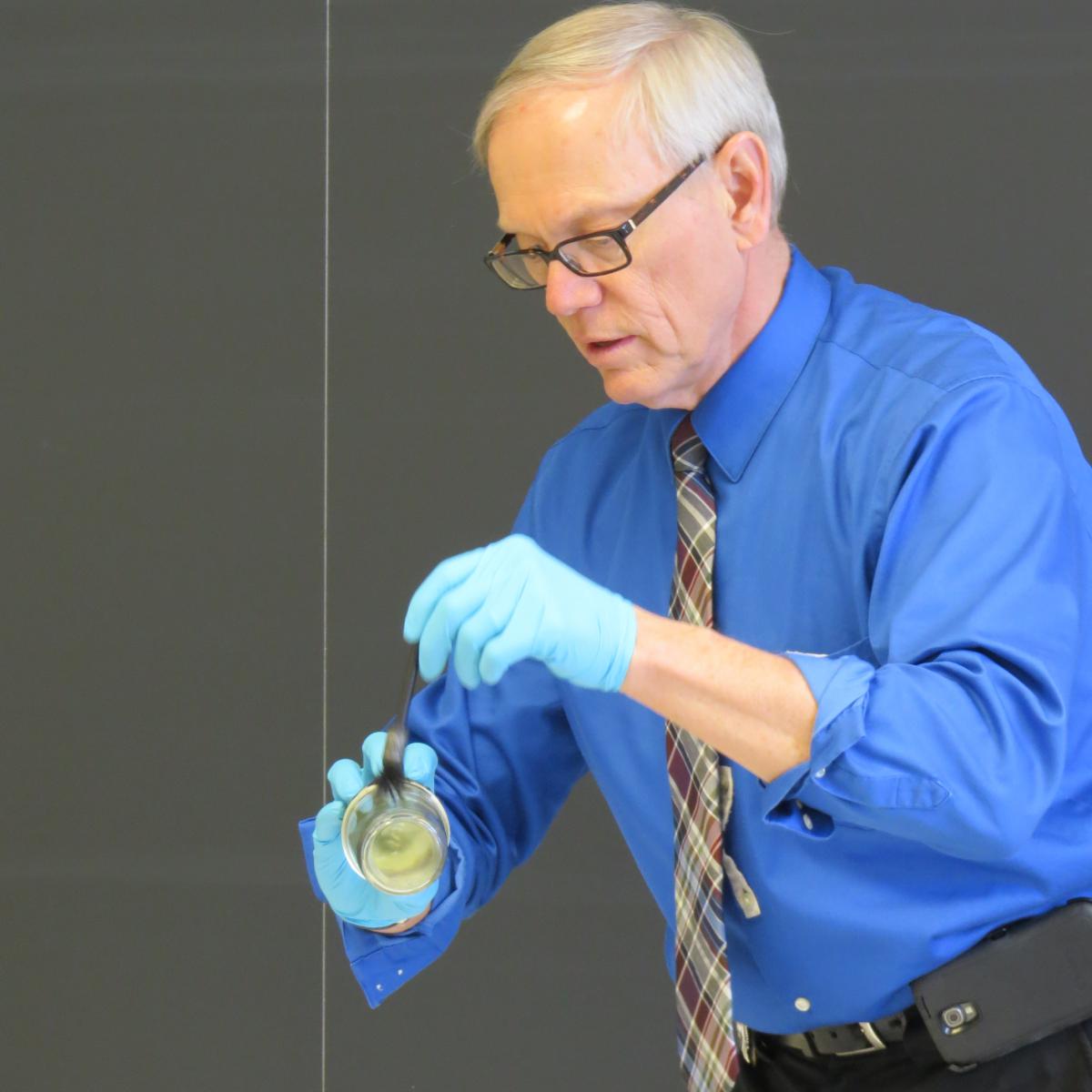 Millcreek Police Lt. Mike Dougan demonstrates evidence collection.