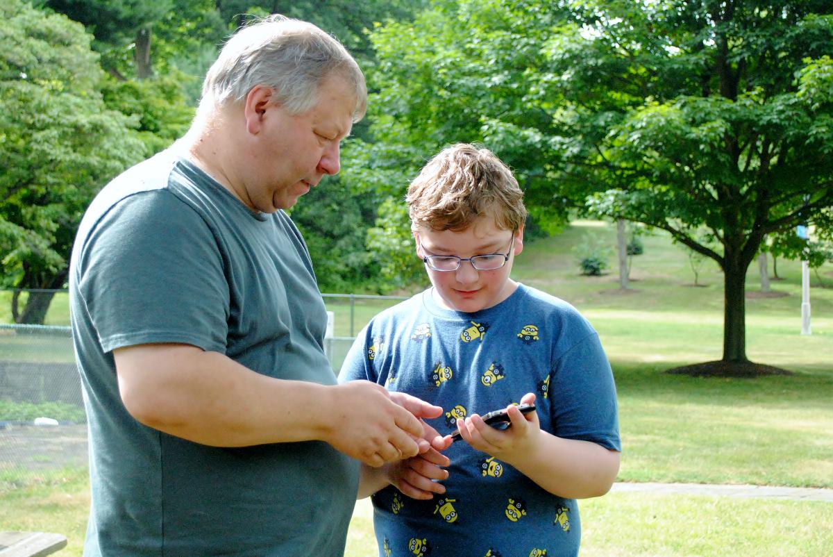 A father and his son look for Pokemon while playing Pokemon Go.