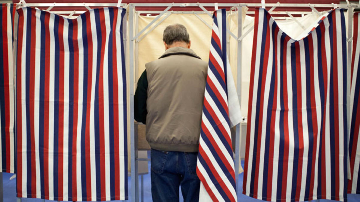 A voter casts his ballot in a voting booth.